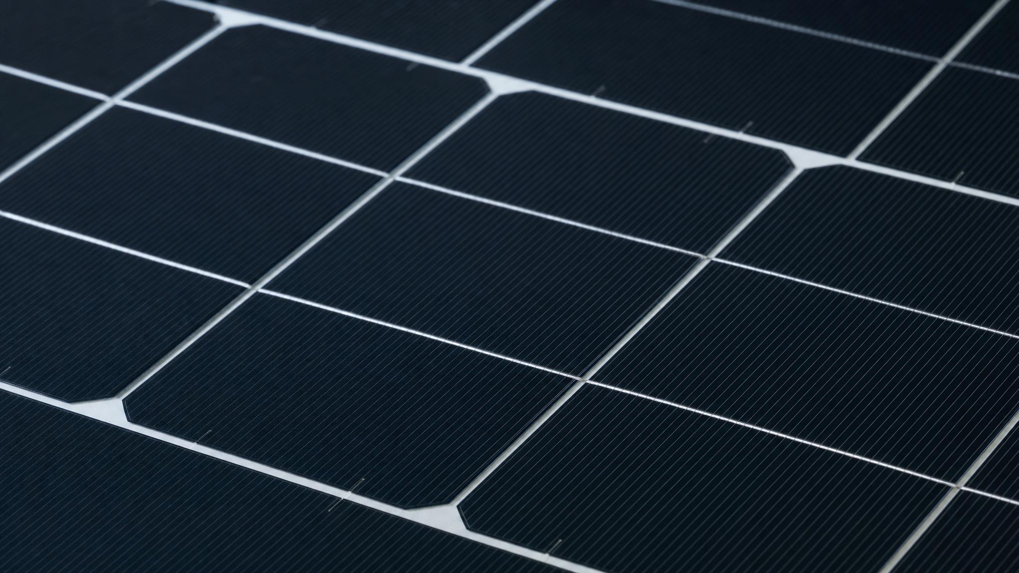 Close-up of modern N-type solar panel cells showing fine silver grid lines and deep blue-black silicon surface