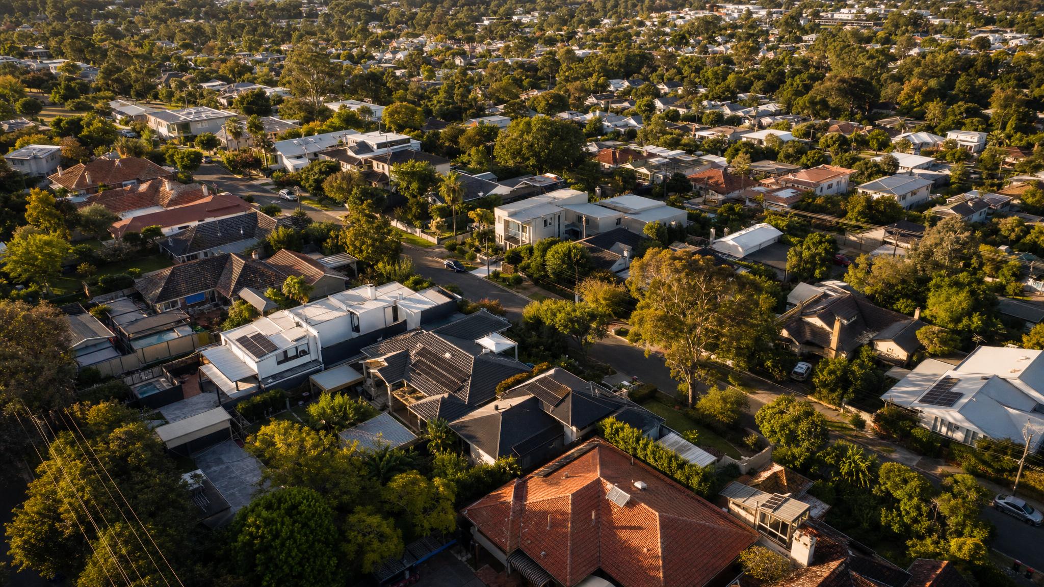 Aerial view of Australian residential suburb with solar panels on rooftops, mix of homes across Melbourne, Sydney and Adelaide